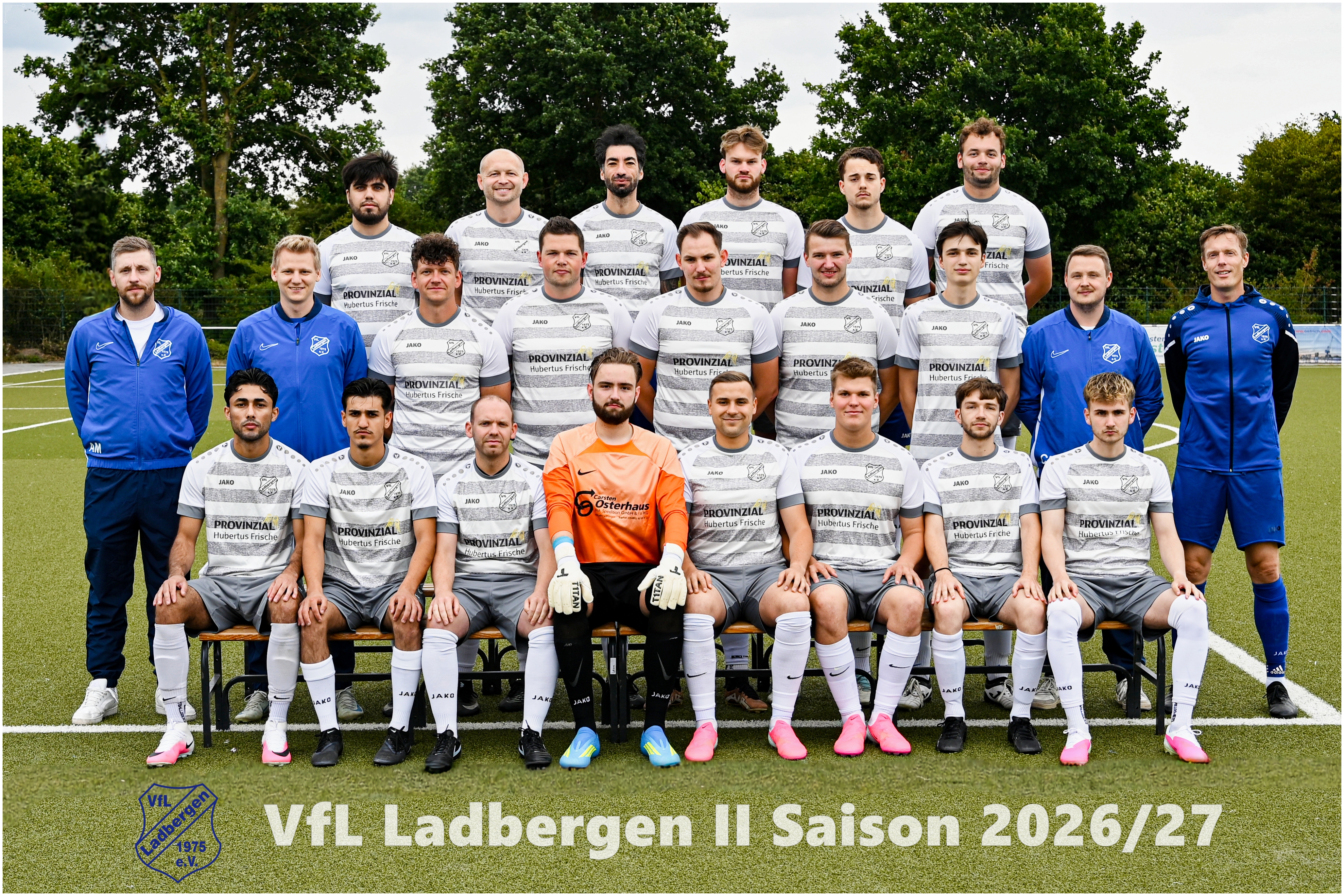 Ernst blickende Fussballmannschaft in weissgrau, Trainer in Blau, gruenes Feld
